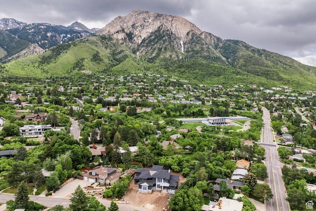 aerial view of property and surrounding area featuring a mountainous background and nearby suburban area