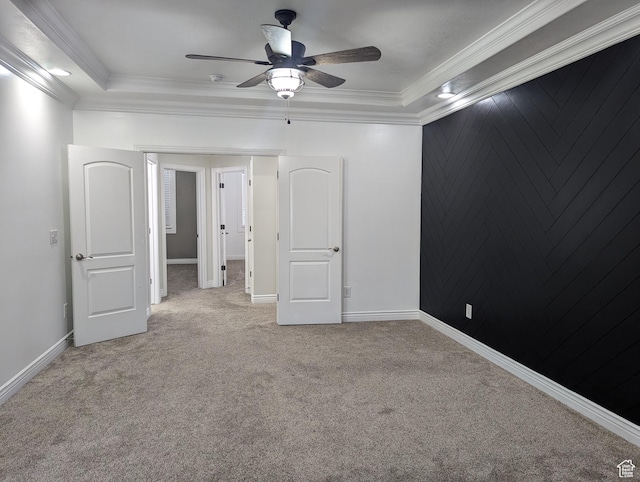 unfurnished bedroom featuring carpet, crown molding, ceiling fan, and baseboards