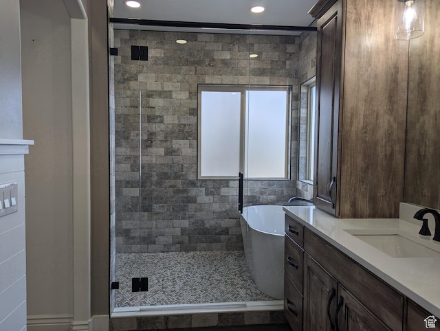 bathroom with a freestanding bath, recessed lighting, a stall shower, and vanity