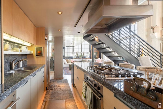 159 W Broadway Unit 411, Salt Lake City, UT 84101 - kitchen with stainless steel appliances, wall chimney exhaust hood, open floor plan, recessed lighting, and light wood-style flooring