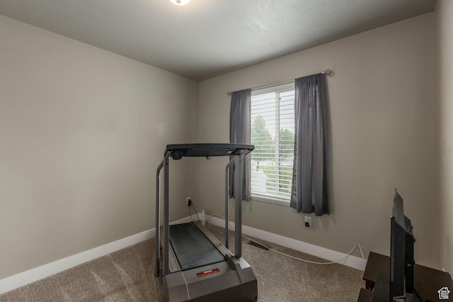 workout room featuring carpet floors and baseboards