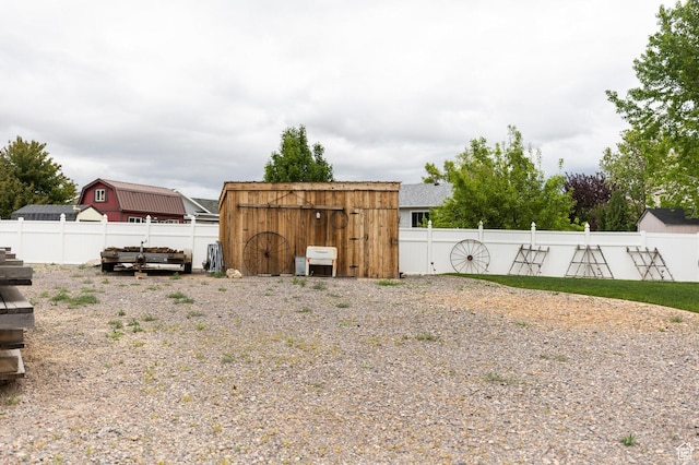 fenced backyard with a storage shed and an outdoor structure
