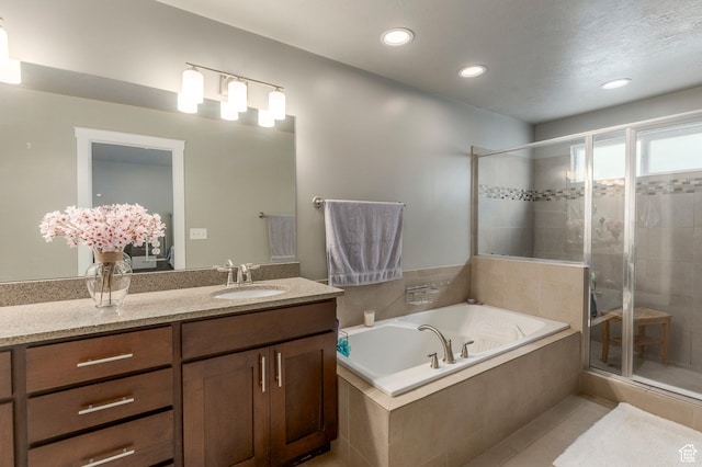 bathroom with a stall shower, a bath, vanity, tile patterned flooring, and recessed lighting