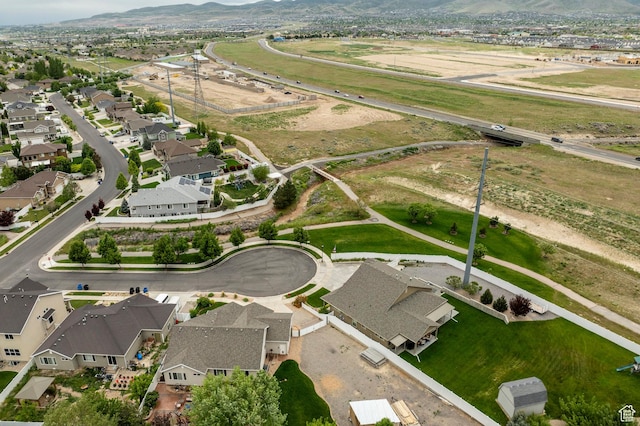 aerial view of property's location with a mountainous background and nearby suburban area
