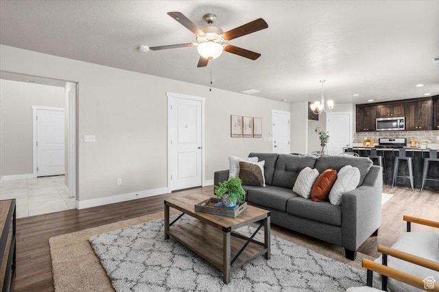 930 N 90 W, Santaquin, UT 84655 - living area with a chandelier, ceiling fan, baseboards, light wood-style floors, and recessed lighting
