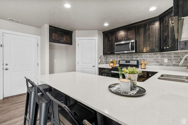 930 N 90 W, Santaquin, UT 84655 - kitchen featuring stainless steel appliances, a sink, tasteful backsplash, recessed lighting, and wood finished floors