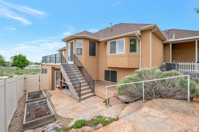 14046 S Emmeline Dr, Herriman, UT 84096 - view of side of property with a garden, stairs, a patio, a fenced backyard, and stucco siding