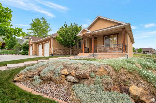 14046 S Emmeline Dr, Herriman, UT 84096 - ranch-style house featuring stucco siding, stone siding, a garage, covered porch, and concrete driveway