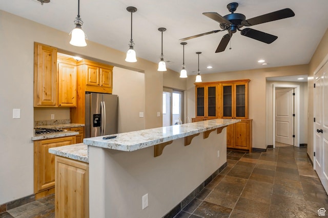14046 S Emmeline Dr, Herriman, UT 84096 - kitchen with stainless steel appliances, a kitchen breakfast bar, ceiling fan, stone tile floors, and recessed lighting