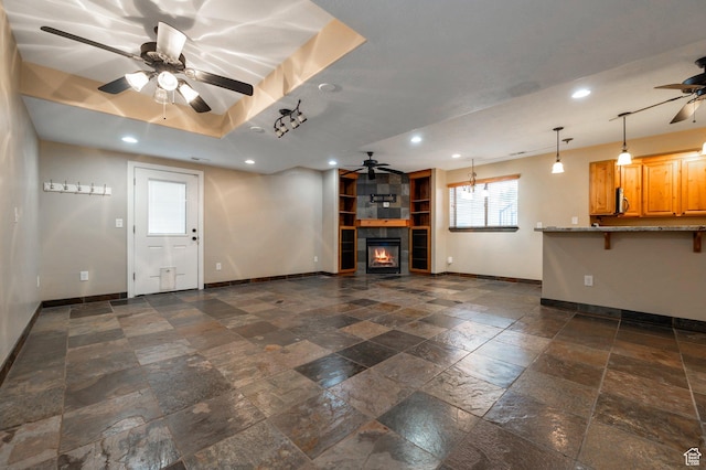 14046 S Emmeline Dr, Herriman, UT 84096 - unfurnished living room featuring a ceiling fan, baseboards, stone tile flooring, recessed lighting, and a tiled fireplace