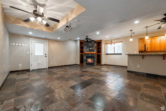 14046 S Emmeline Dr, Herriman, UT 84096 - unfurnished living room with a ceiling fan, baseboards, stone tile floors, recessed lighting, and a fireplace