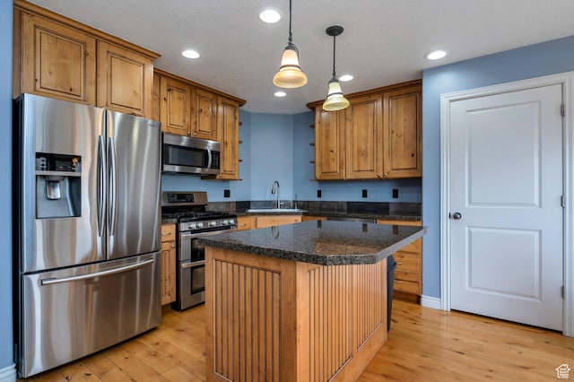 14046 S Emmeline Dr, Herriman, UT 84096 - kitchen featuring appliances with stainless steel finishes, a sink, light wood-style floors, dark countertops, and a center island