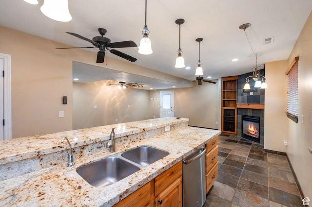 14046 S Emmeline Dr, Herriman, UT 84096 - kitchen featuring dishwasher, dark stone finish floors, a sink, a tiled fireplace, and a ceiling fan