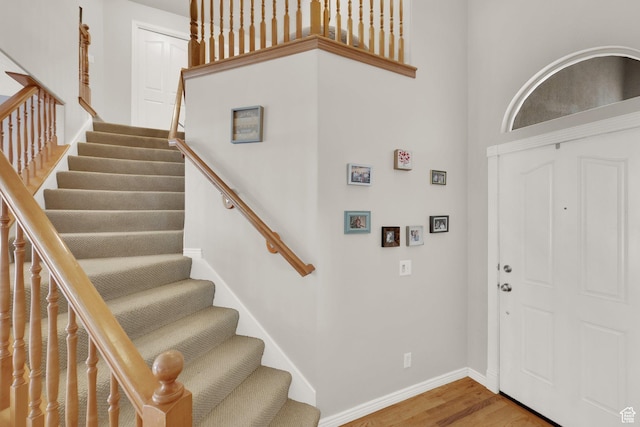 entrance foyer featuring stairs, wood finished floors, and baseboards