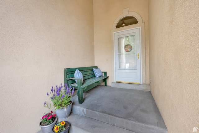 doorway to property featuring stucco siding