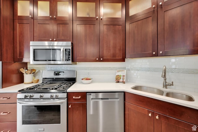 kitchen featuring appliances with stainless steel finishes, a sink, and light countertops