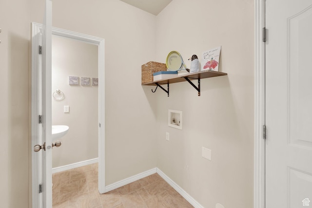 washroom with washer hookup and baseboards