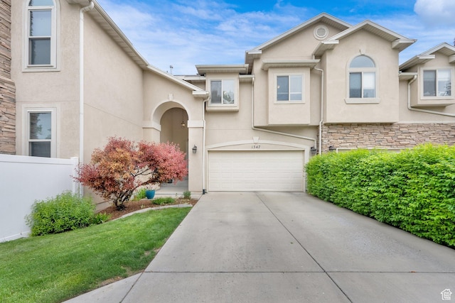 view of front facade with stucco siding, driveway, and a garage