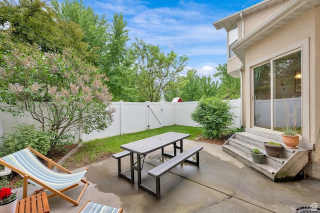 view of patio featuring outdoor dining space, a fenced backyard, and entry steps