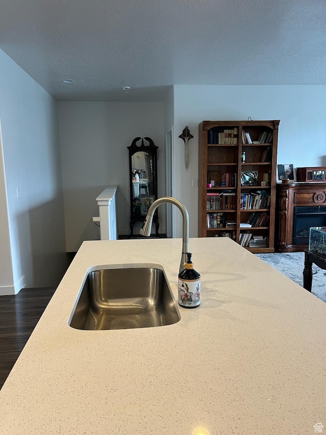7747 N Seabiscuit Rd, Eagle Mountain, UT 84005 - kitchen featuring a sink, a textured ceiling, wood finished floors, and baseboards