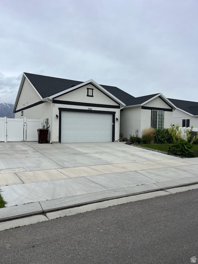 7747 N Seabiscuit Rd, Eagle Mountain, UT 84005 - single story home with stucco siding, an attached garage, a gate, concrete driveway, and fence