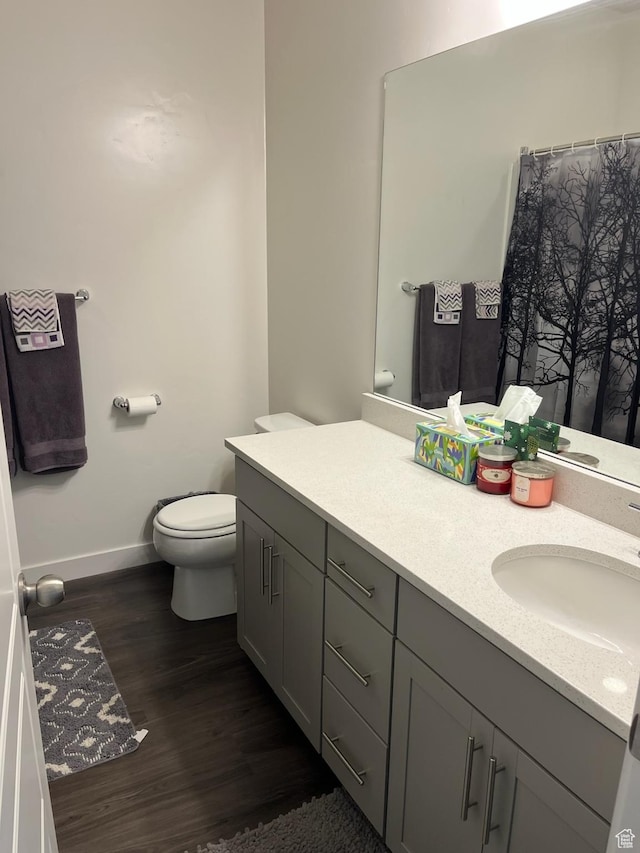 7747 N Seabiscuit Rd, Eagle Mountain, UT 84005 - bathroom with baseboards, wood finished floors, toilet, and vanity