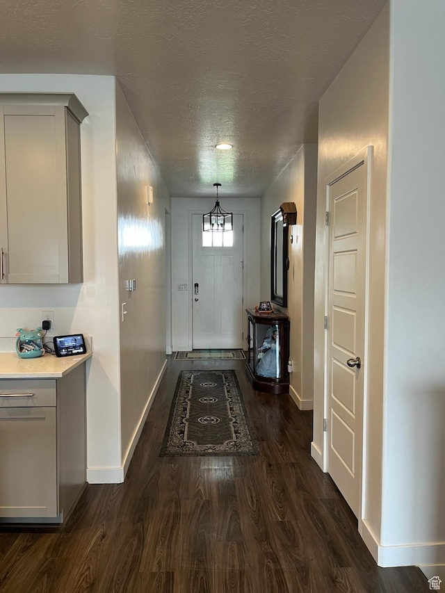7747 N Seabiscuit Rd, Eagle Mountain, UT 84005 - entrance foyer featuring baseboards, dark wood finished floors, and a textured ceiling