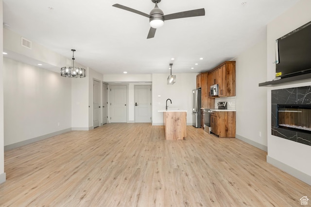 35 E 150th St S Unit D101, Garden City, UT 84028 - unfurnished living room featuring light wood-style flooring, a ceiling fan, baseboards, a high end fireplace, and recessed lighting