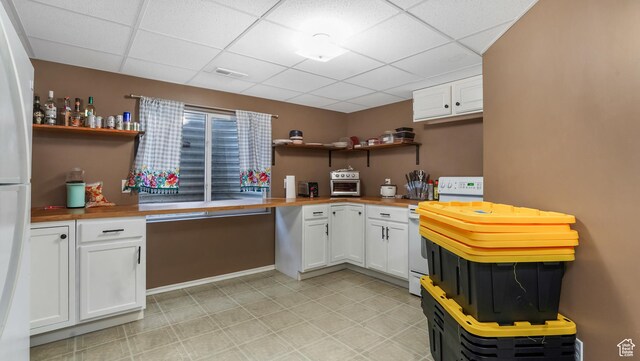 kitchen featuring open shelves, white appliances, butcher block countertops, a paneled ceiling, and white cabinetry