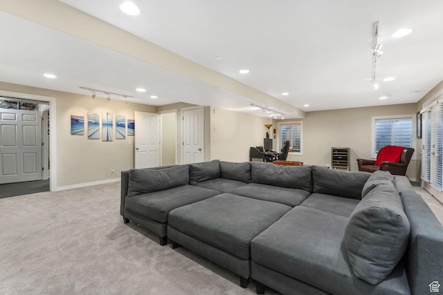 living area with rail lighting, light colored carpet, baseboards, recessed lighting, and beverage cooler