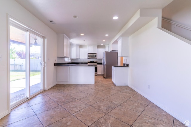 886 Cambridge Dr, North Salt Lake, UT 84054 - kitchen with stainless steel appliances, dark countertops, white cabinetry, recessed lighting, and a sink