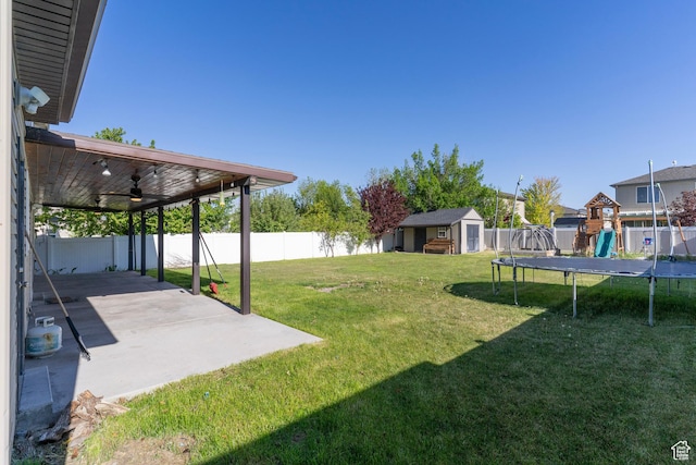 886 Cambridge Dr, North Salt Lake, UT 84054 - view of yard featuring a trampoline, a storage unit, a patio area, an outbuilding, and ceiling fan