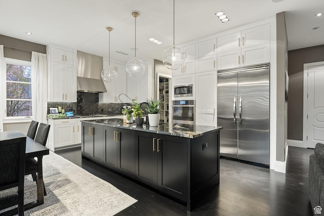 54 N B St, Salt Lake City, UT 84103 - kitchen featuring built in appliances, wall chimney range hood, white cabinets, dark stone countertops, and dark cabinets