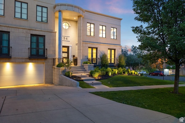 54 N B St, Salt Lake City, UT 84103 - view of front of home featuring concrete driveway, a front lawn, a garage, and stucco siding