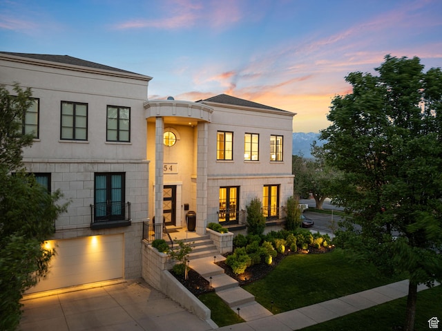 54 N B St, Salt Lake City, UT 84103 - view of front of property with french doors, an attached garage, stucco siding, and driveway