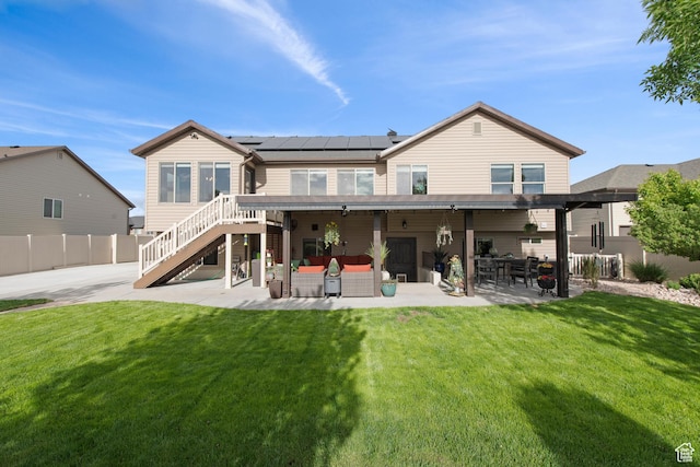 rear view of house featuring an outdoor living space, a patio, solar panels, and stairway