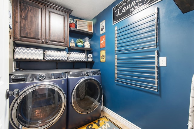 laundry area with independent washer and dryer, cabinet space, and baseboards