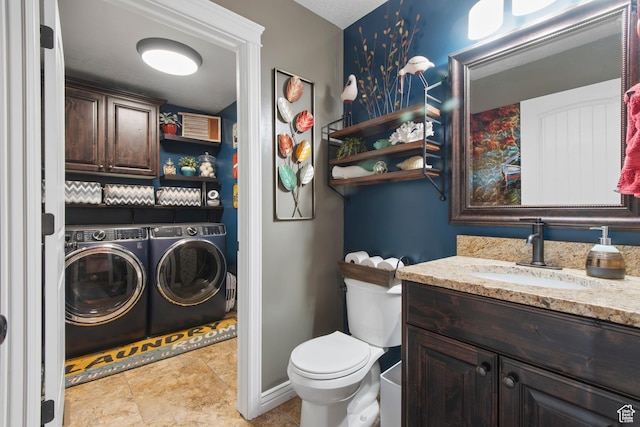 bathroom with washer and clothes dryer, toilet, and vanity