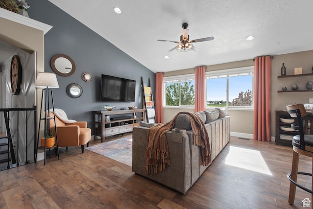 living area with a ceiling fan, vaulted ceiling, wood finished floors, a textured ceiling, and recessed lighting