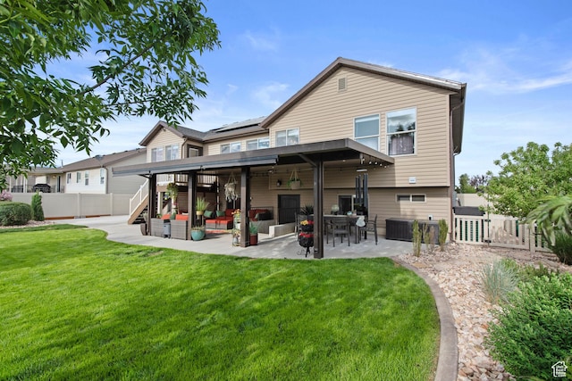 rear view of property with a patio area, a gate, roof mounted solar panels, and stairway