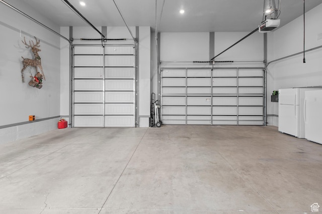 garage featuring a garage door opener and freestanding refrigerator