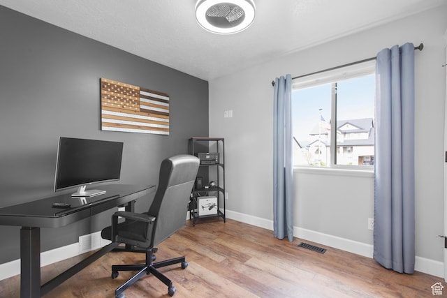 home office with baseboards and wood finished floors