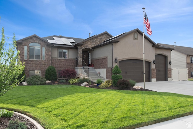 view of front of home featuring a garage, stucco siding, a front yard, solar panels, and driveway