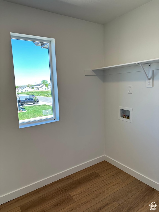 laundry area with hookup for a washing machine, wood finished floors, and baseboards