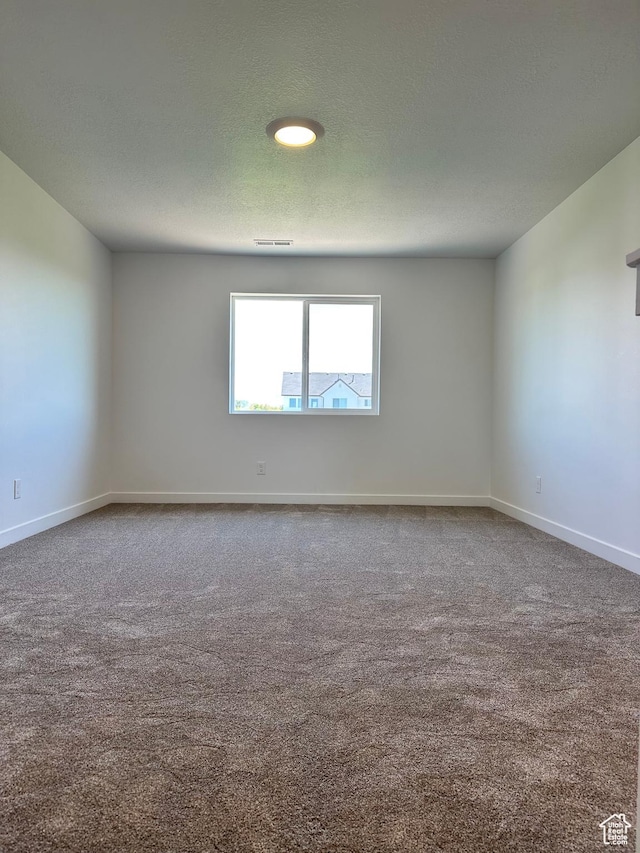 carpeted empty room featuring baseboards