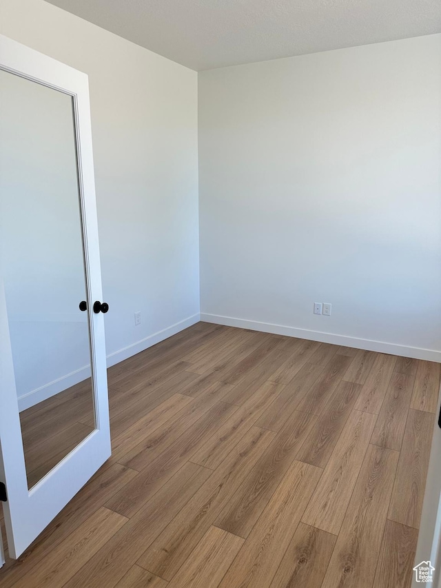empty room with wood finished floors and baseboards