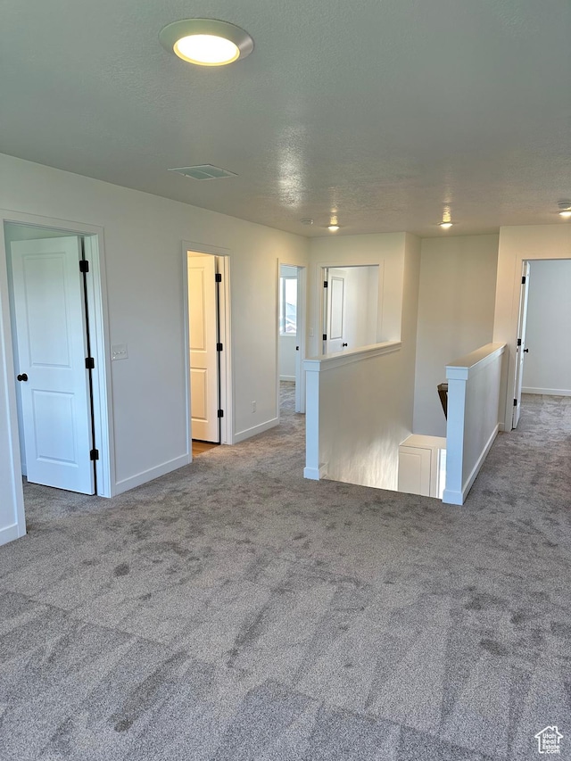 carpeted empty room featuring baseboards