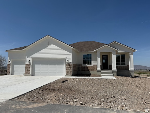 single story home with brick siding, a garage, concrete driveway, and roof with shingles