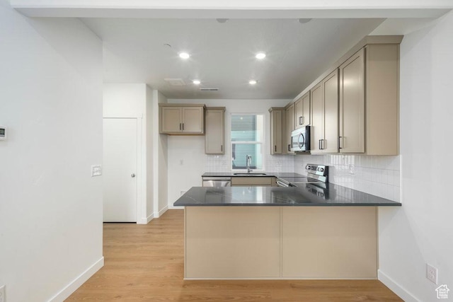 309 W Azure Sky Ln Unit 5-26, Salt Lake City, UT 84103 - kitchen featuring stainless steel appliances, decorative backsplash, a peninsula, dark countertops, and baseboards