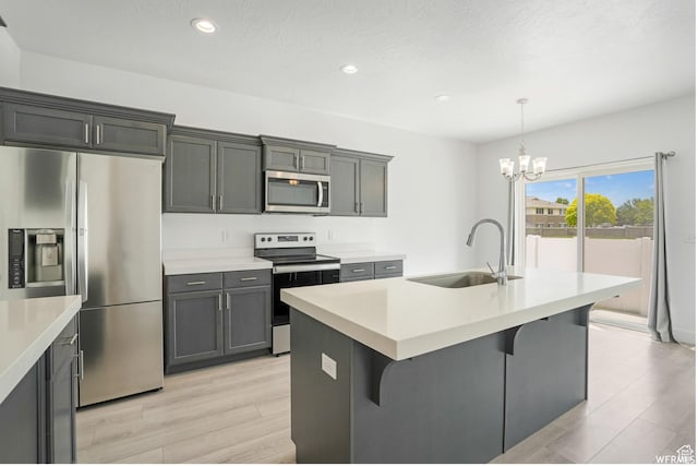 172 S 880 E, American Fork, UT 84003 - kitchen featuring appliances with stainless steel finishes, a sink, a chandelier, light wood-style flooring, and a kitchen bar